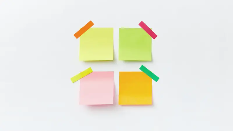 Notes autocollantes de couleur disposées sur un mur blanc