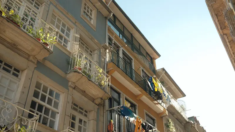 Façades d'immeubles anciens en pierre avec balcons en fer forgé et linge qui sèche