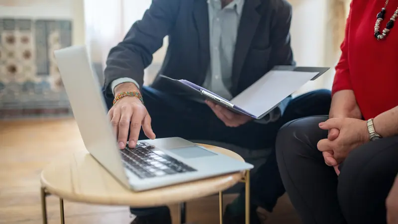 Rendez-vous de travail autour d'un ordinateur portable et d'un document