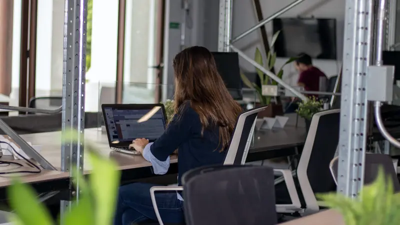 Femme travaillant sur un ordinateur portable dans un espace de coworking lumineux