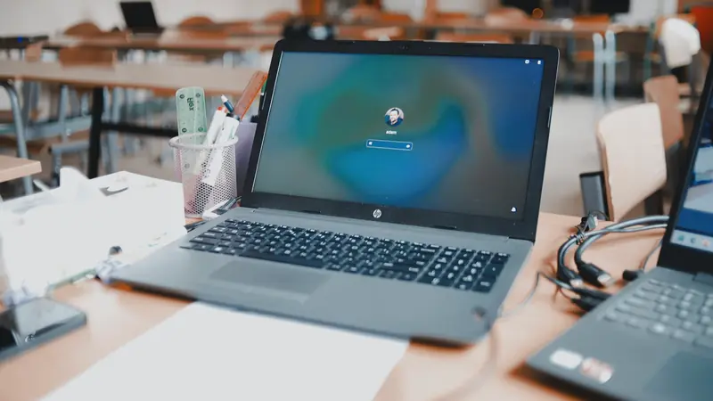 Ordinateur portable posé sur une table de salle de classe, écran de connexion affiché