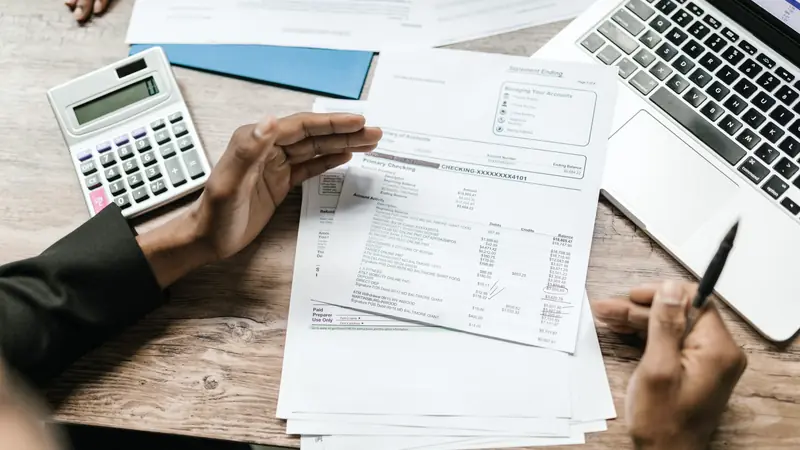 Facture imprimée, calculatrice et ordinateur portable sur un bureau en bois