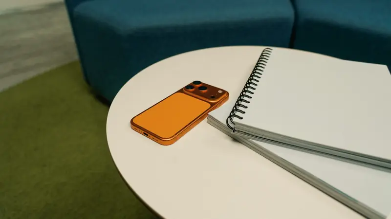 Téléphone et carnets posés sur une table ronde dans un espace d'accueil