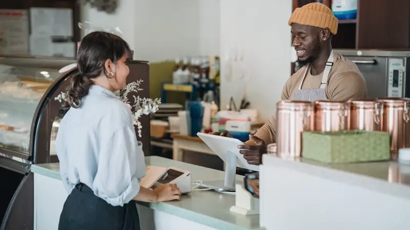 Cliente servie au comptoir d'un café-boutique