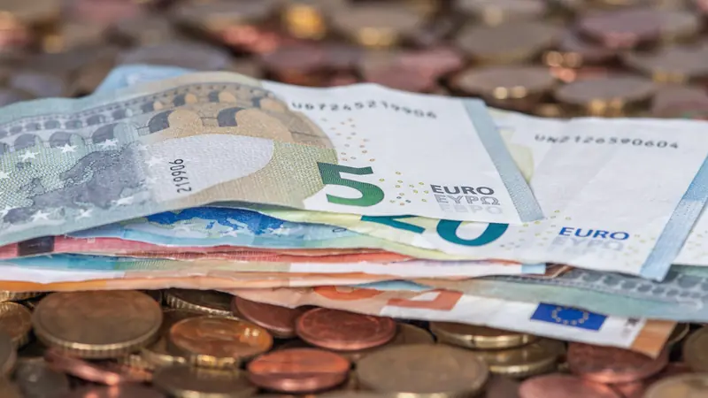 Billets et pièces en euros étalés sur une table