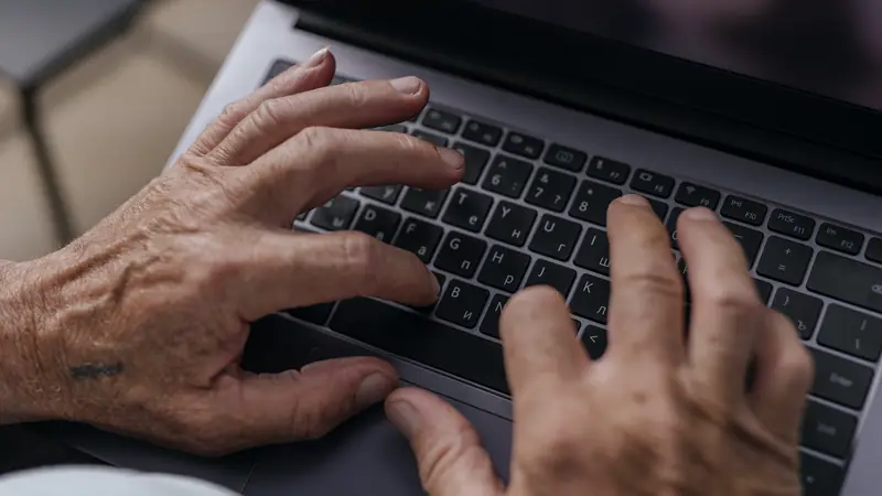 Gros plan sur deux mains qui tapent sur le clavier d'un ordinateur portable