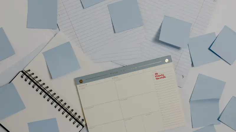 Notes autocollantes bleues et planning hebdomadaire disposés sur un bureau