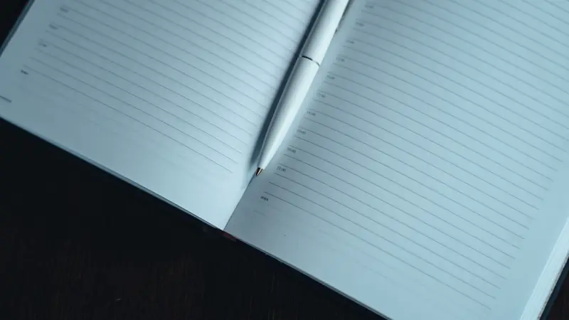 Carnet ouvert aux pages lignées avec un stylo