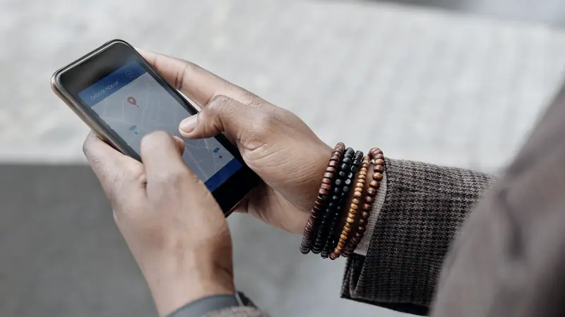 Mains tenant un smartphone affichant une carte dans la rue