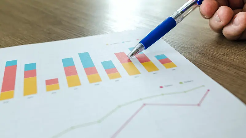 Stylo pointant un graphique en barres imprimé sur un bureau