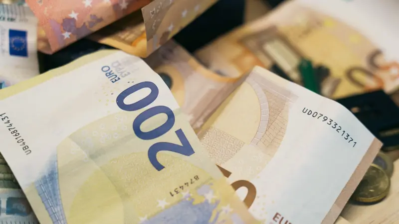 Gros plan sur des billets de 200 et 50 euros mêlés à quelques pièces