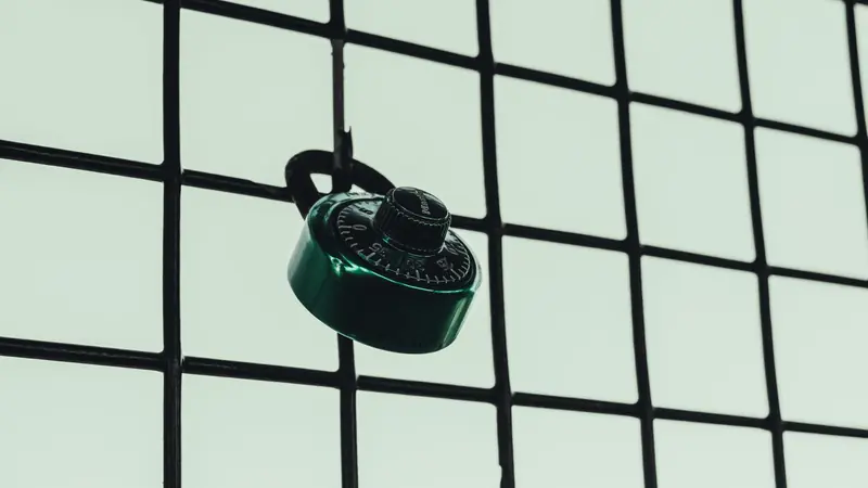 Cadenas à combinaison vert accroché à un grillage métallique